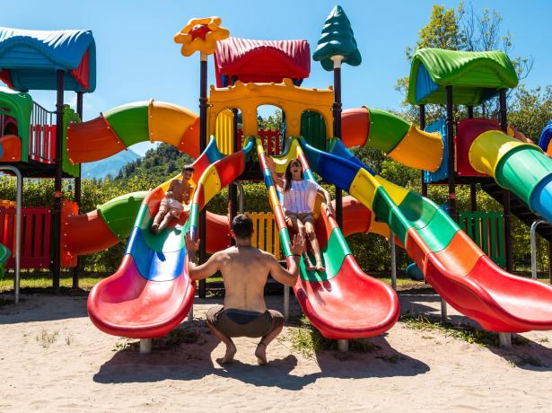 Playground with colorful slides and happy children playing.