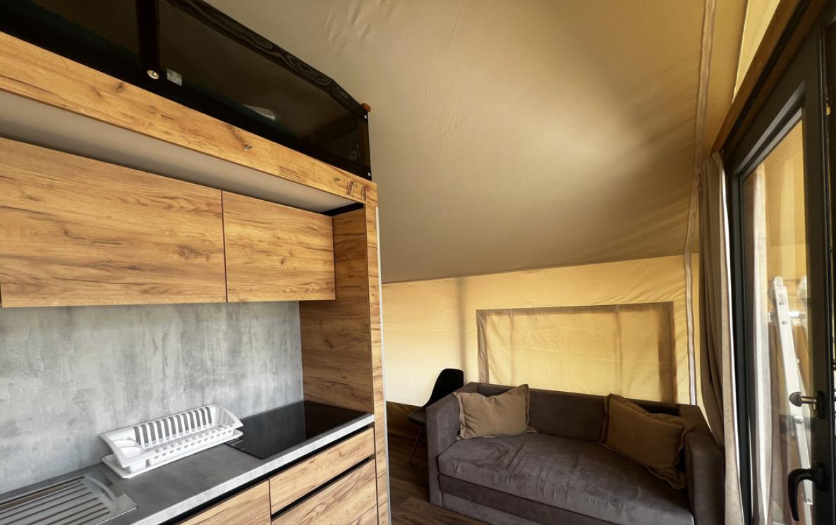 Elegant interieur met houten keuken en grijze bank.