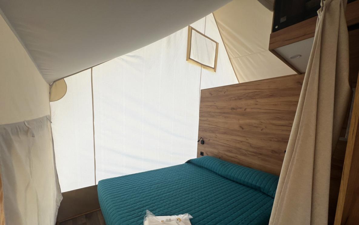 Slaapkamer met tweepersoonsbed en canvaswanden.