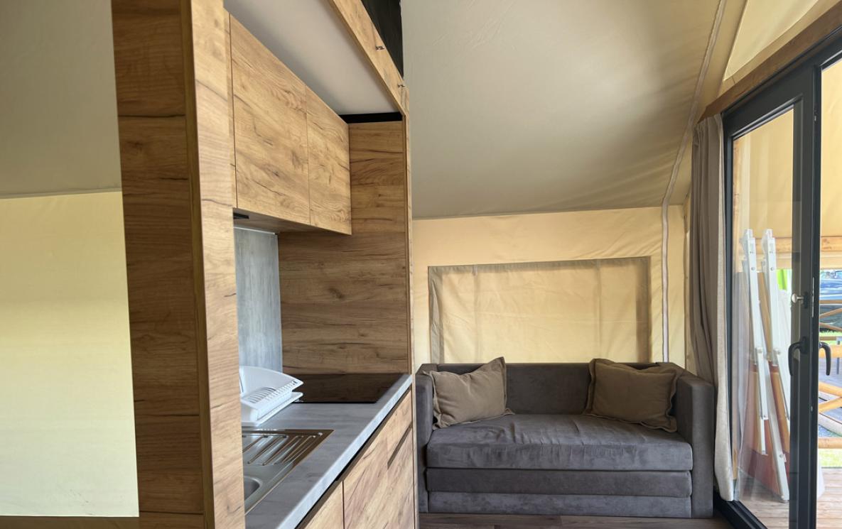 Modern interieur met keuken en bank, hout en neutrale tinten.