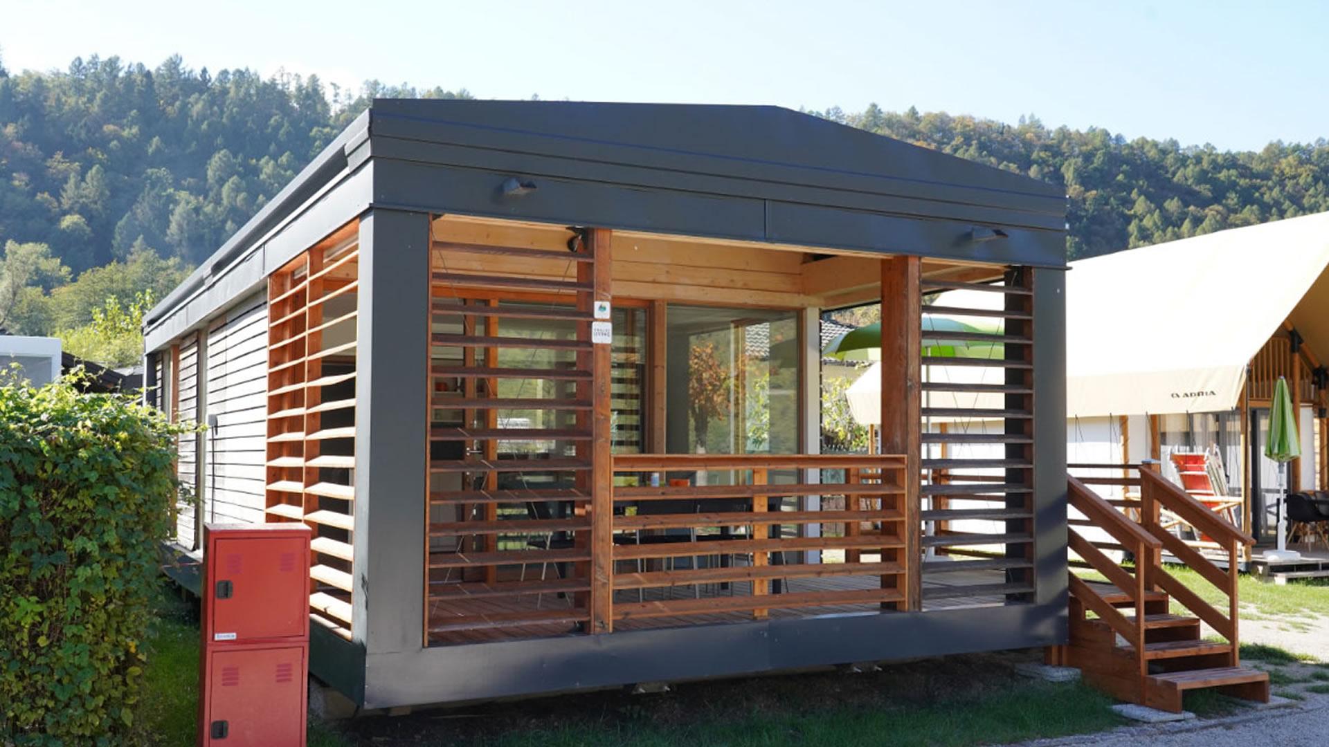 Modernes Haus mit Holzveranda in natürlicher Umgebung.