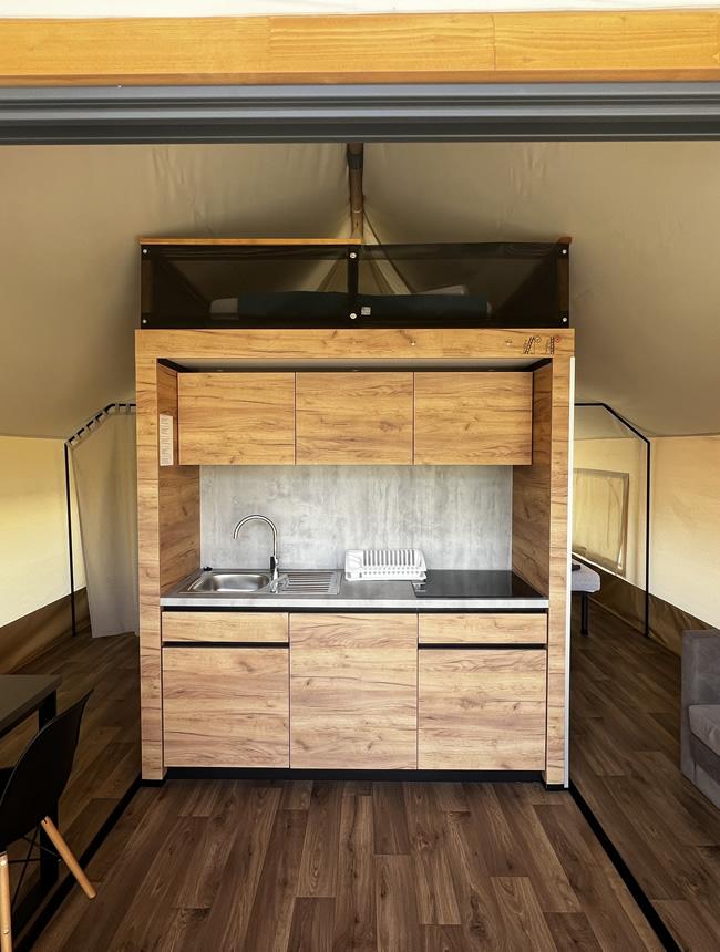 Compacte houten keuken met gootsteen en kasten.